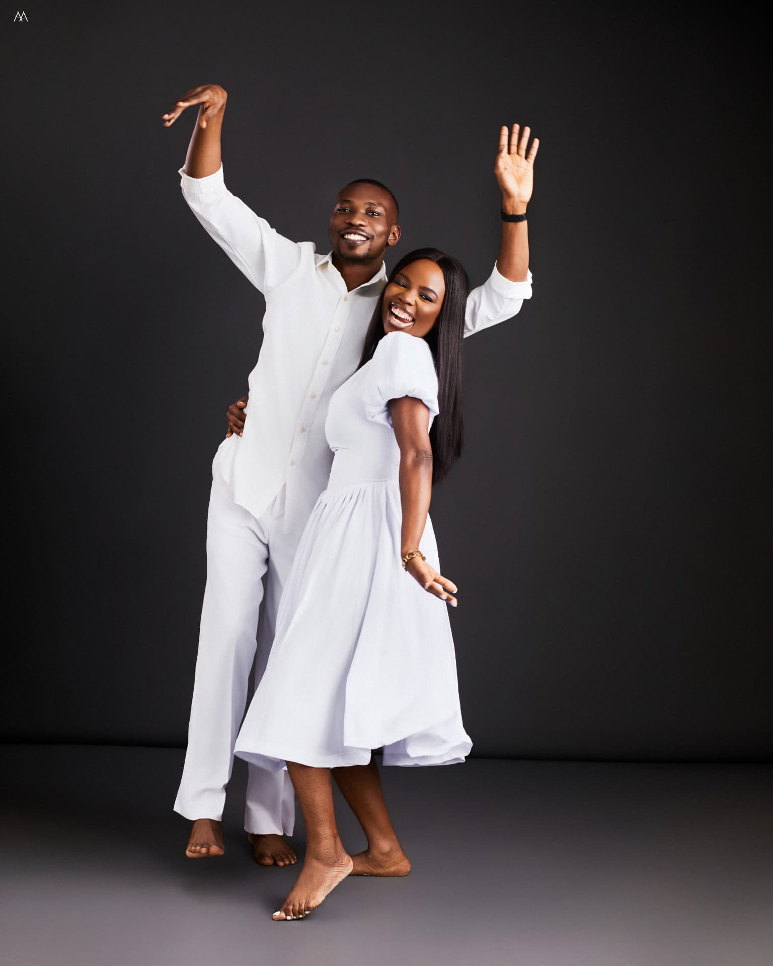 Oluwaseun and Oluwatobiloba laughing together in white outfits